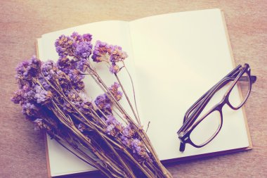 defter, statice çiçek ve gözlük