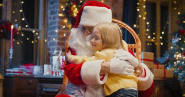 Noel Baba 'yı seviyorum. Güzel kızın dizlerinin üzerinde otururken Noel Baba 'yı kucakladığı belden yukarı portre görüntüsü. Tatil kavramı