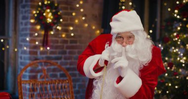 Noel Baba kostümlü mutlu son sınıf öğrencisinin belindeki portre görüntüsü evde vakit geçirirken hediyelerle dolu. Tatil kavramı