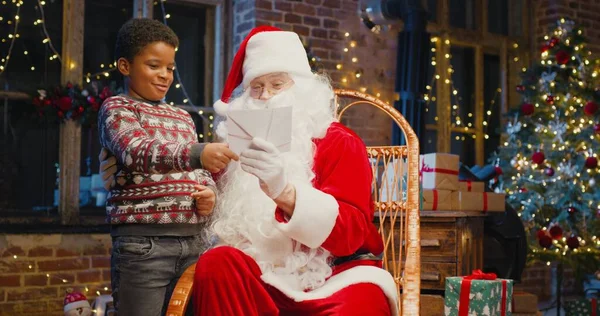 Nahaufnahme Porträt des Weihnachtsmannes mit einem kleinen Jungen, der zusammen spielt. Frohe Weihnachten und frohe Feiertage. Neujahrsfeier — Stockfoto
