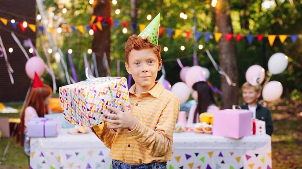 Feliz aniversário caucasiano criança tremendo presente de aniversário desembrulhado. O rapaz saiu para abrir o presente de aniversário. Conceito de celebração de aniversário — Fotografia de Stock