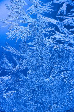 Camdaki buz dokusu, donmuş bir pencerenin buzlu yüzeyi, arka plan, mavi monokrom..