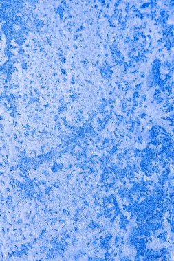 Camdaki buz dokusu, donmuş bir pencerenin buzlu yüzeyi, arka plan, mavi monokrom..