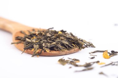 beyaz arka plan üzerinde izole ahşap bir kaşık üzerinde aromatik yeşil kuru çay,