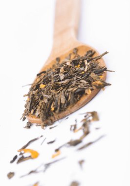 beyaz arka plan üzerinde izole ahşap bir kaşık üzerinde aromatik yeşil kuru çay,