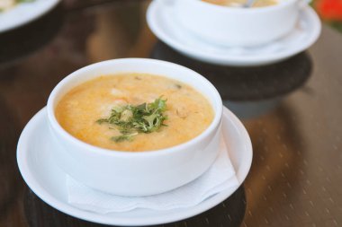 Bir kase tavuk ya da sebzeli çorba restoranın masasında nefis ev yapımı beyaz tabakta çorba.