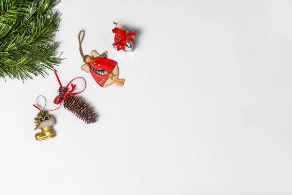 クリスマスの構図 白い背景にクリスマスギフト おもちゃ 松のコーンとモミの枝 フラットレイアウト トップビューコピースペース — ストック写真