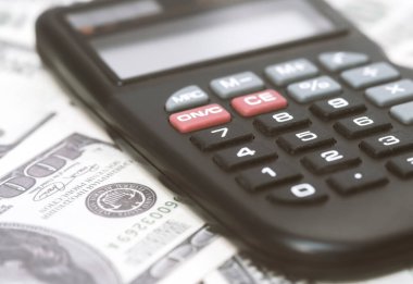 Birkaç dolar ve masa üzerinde bir hesap makinesi, finans ve tasarruf. İş konsepti
