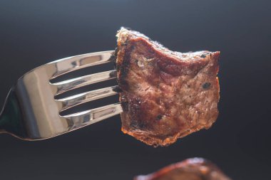 Çatal, koyu arka plan üzerinde et parçası