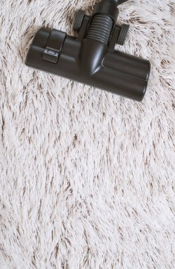 Bir kalın kazık beyaz carpet.still hayat koyu tonu vakumlama sırasında kullanılan modern elektrikli süpürge Başkanı yakın çekim.