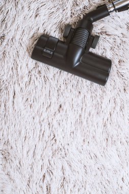 Bir kalın kazık beyaz carpet.still hayat koyu tonu vakumlama sırasında kullanılan modern elektrikli süpürge Başkanı yakın çekim.