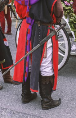 Bir adam bir ortaçağ tarzı kostüm ve kılıç arkadan görünüm.