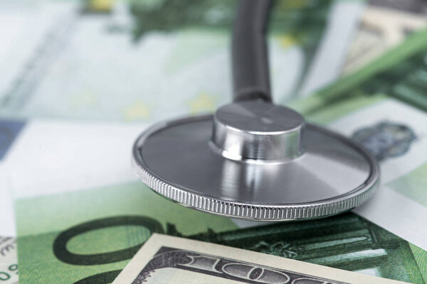 medical stethoscope on dollars and euro banknotes