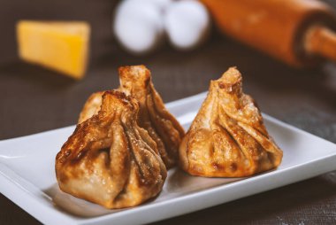 Gürcistan usulü kızarmış Khinkali köftesi ve ahşap masada beyaz tabakta et. Geleneksel Kafkas mutfağı yemeği.