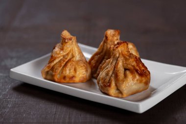 Gürcistan usulü kızarmış Khinkali köftesi ve ahşap masada beyaz tabakta et. Geleneksel Kafkas mutfağı yemeği.