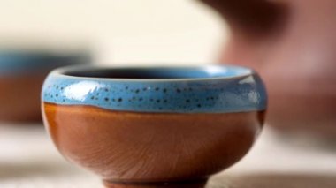 Pouring tea into a  cup from a clay teapot. Tea ceremony. Japan or China