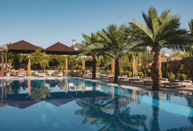 Lüks tropik tatil köyünde yüzme havuzu. Lüks tropikal tatil beldesindeki plaj salonlarıyla yüzme havuzu..