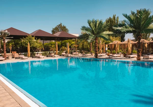 Lüks tropik tatil köyünde yüzme havuzu. Lüks tropikal tatil beldesindeki plaj salonlarıyla yüzme havuzu..