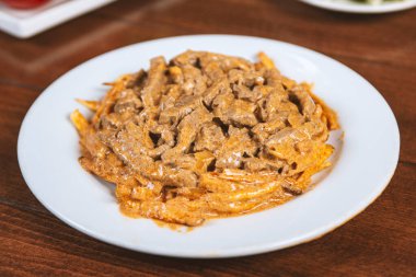 Beyaz tabakta patates kızartmalı biftek Stroganoff..