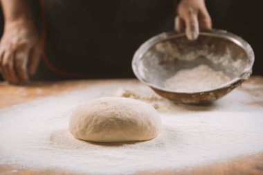 Hamur yoğurma fırını. Aşçı ahşap masada turta pişirmek için hamur yapıyor. İşlem hazırlığı ev yapımı hamur işi. Makarna, ekmek, spagetti, khachapuri, yemek konsepti.