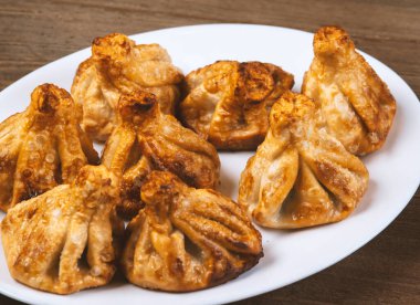 Beyaz bir tabakta kızarmış khinkali. Gürcü mutfağı..