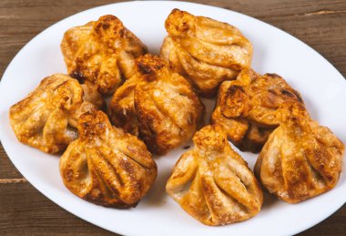 Beyaz bir tabakta kızarmış khinkali. Gürcü mutfağı..