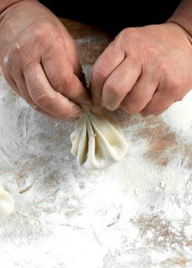 Aşçı ahşap masada khinkali yapıyor. İşlem hazırlığı Gürcistan yemeği. yiyecek konsepti.