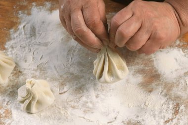 Aşçı ahşap masada khinkali yapıyor. İşlem hazırlığı Gürcistan yemeği. yiyecek konsepti.