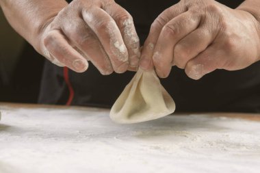 Aşçı ahşap masada khinkali yapıyor. İşlem hazırlığı Gürcistan yemeği. yiyecek konsepti.