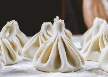 Aşçı ahşap masada khinkali yapıyor. İşlem hazırlığı Gürcistan yemeği. yiyecek konsepti.