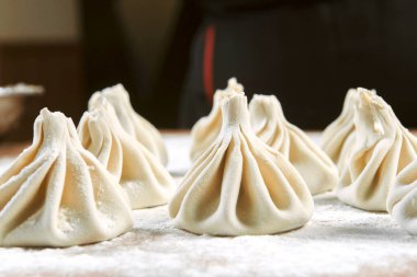 Aşçı ahşap masada khinkali yapıyor. İşlem hazırlığı Gürcistan yemeği. yiyecek konsepti.