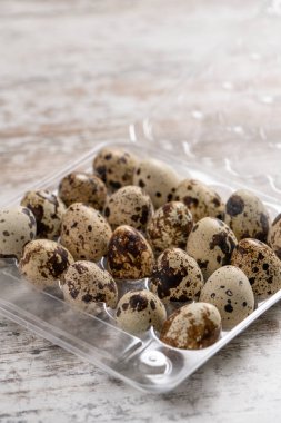 Tahta bir masada plastik kaplarda bıldırcın yumurtaları.