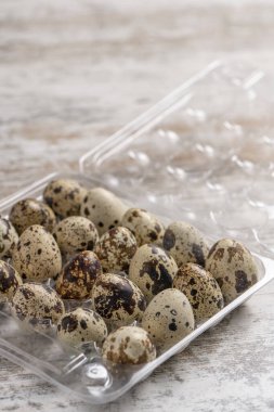 Tahta bir masada plastik kaplarda bıldırcın yumurtaları.