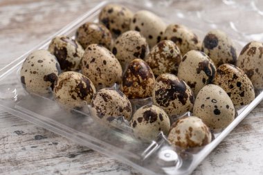 Tahta bir masada plastik kaplarda bıldırcın yumurtaları.