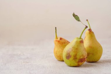 üç sarı sonbahar armudu beyaz ahşap bir zemin