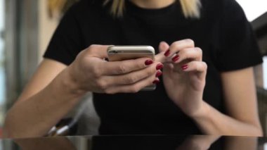  Blonde woman sitting and using her phone