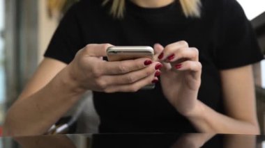  Blonde woman sitting and using her phone