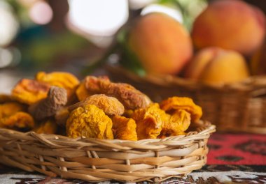 Kurumuş meyve ve taze şeftali meyveleri sepette yapraklar ve kırsal arka plan