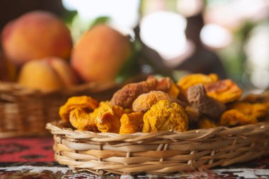 Kurumuş meyve ve taze şeftali meyveleri sepette yapraklar ve kırsal arka plan