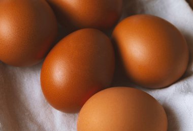 Keten havluyla kaplanmış hasır sepetteki tavuk yumurtaları...