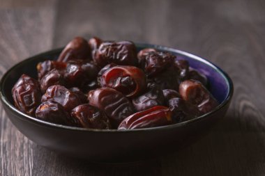 Beyaz ahşap arka planda fındık ve hurma karışımı sağlıklı yiyecekler.