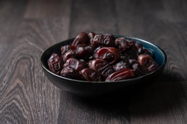 Beyaz ahşap arka planda fındık ve hurma karışımı sağlıklı yiyecekler.