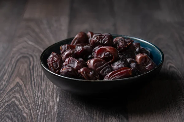 Beyaz ahşap arka planda fındık ve hurma karışımı sağlıklı yiyecekler.