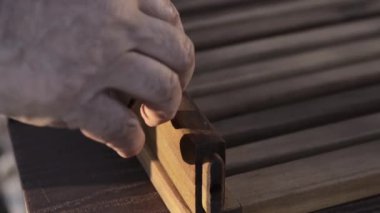 A man collects furniture. Tightens the screws.