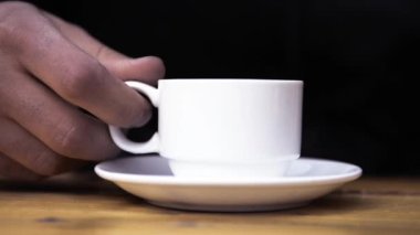 Man drinks a cup of strong coffee in cafe .