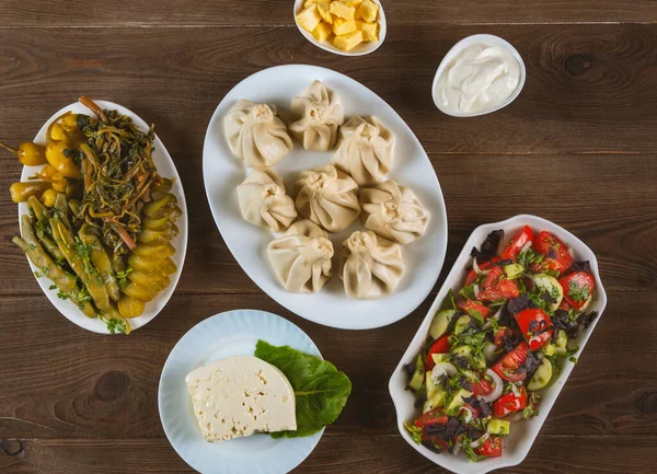 Khinkali, peynir, turşu ve salatadan yapılmış Gürcü mutfağı. Üst görünüm.