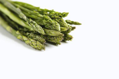 Beyaz arka planda bir demet taze kuşkonmaz.