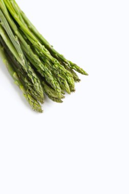 Beyaz arka planda bir demet taze kuşkonmaz.