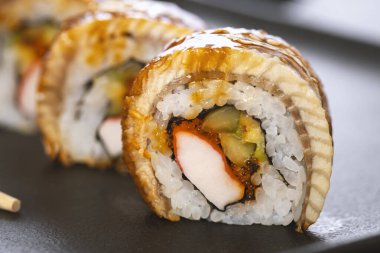 Pilavlı suşi, yengeç, salatalık, avokado, tobiko, yılan balığı. Suşi menüsü. Japon yemeği..