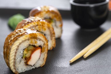 Pilavlı suşi, yengeç, salatalık, avokado, tobiko, yılan balığı. Suşi menüsü. Japon yemeği..